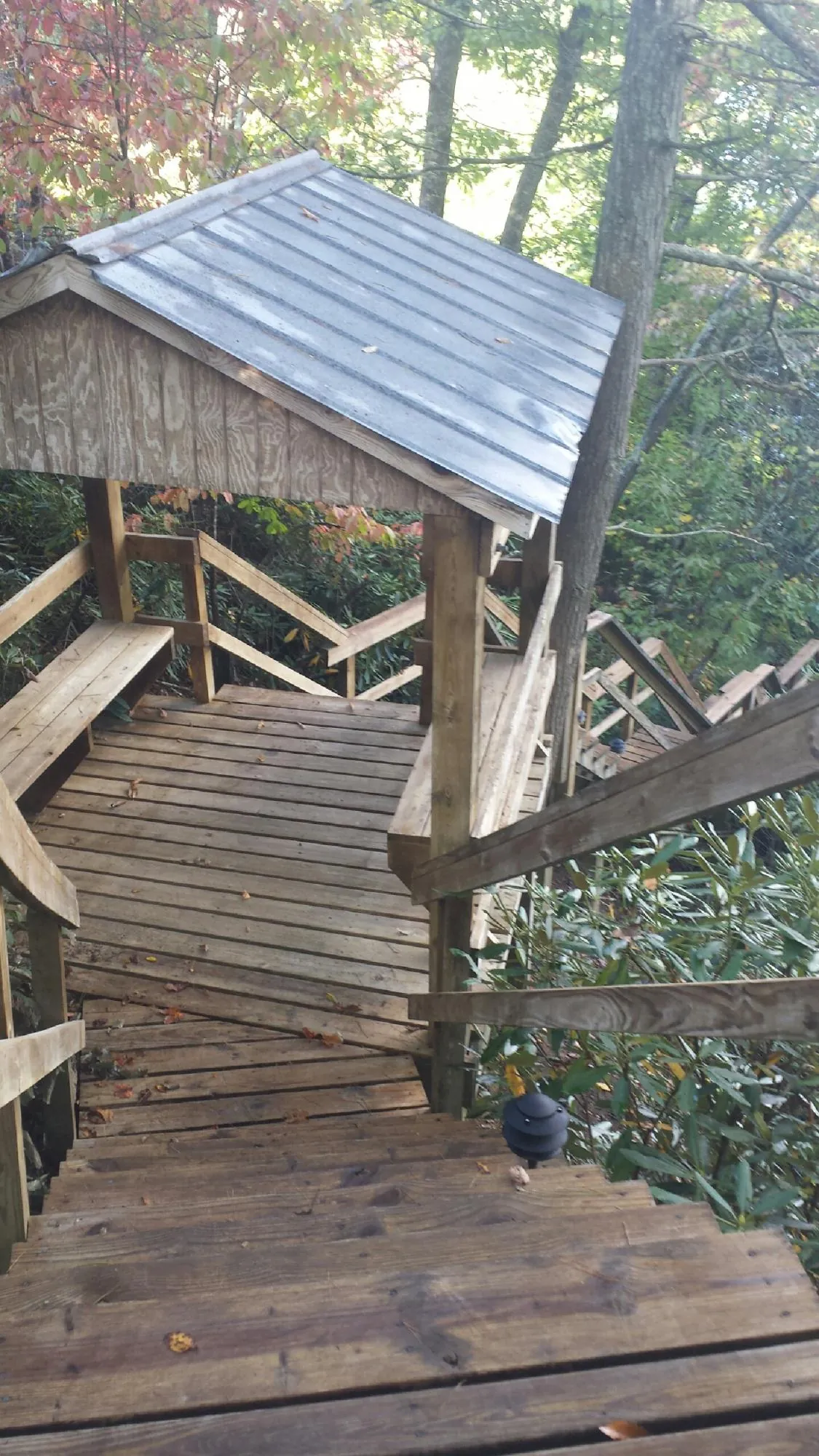 Metal roofed shelter over wooden steps on a wooded walkway — Skylight Repair & Installation work by our crew in West Yellowstone