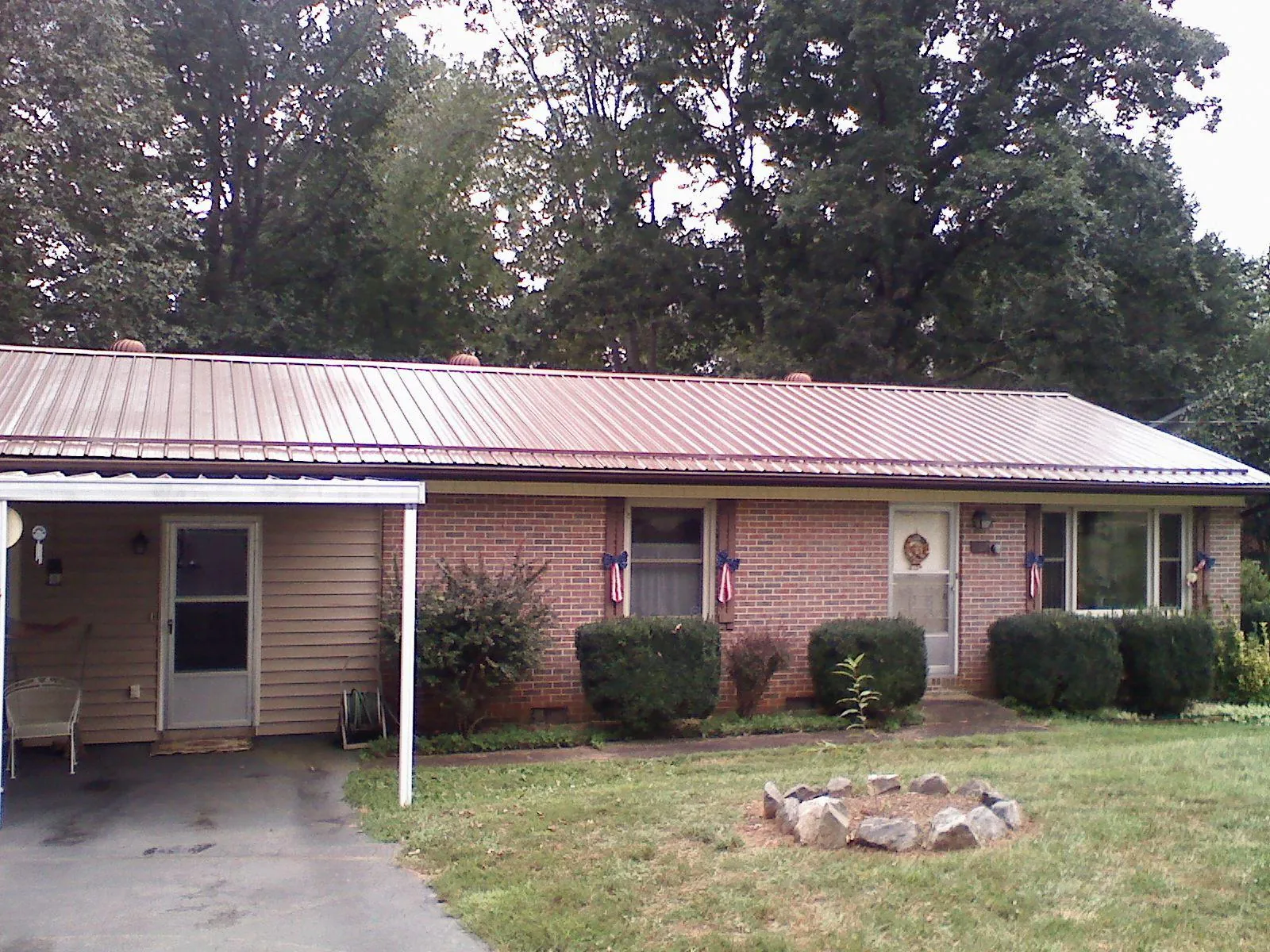 Bronze metal roof and carport on a brick ranch home — Roof Repair work by our crew in West Yellowstone